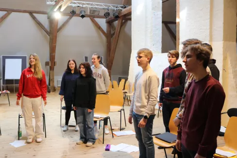 eine Gruppe Sängerinnen und Sänger der Young Voices Brandenburg sind bei der Probe zu sehen