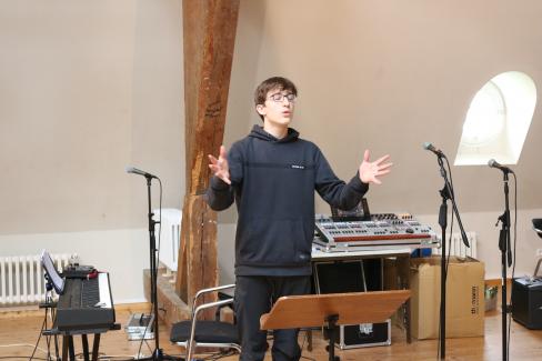 ein junger Sänger der Young Voices Brandenburg dirigiert den Chor bei der Probe