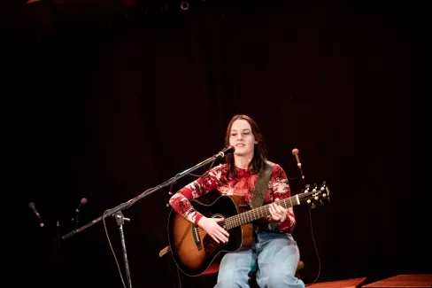 Sängerin mit Gitarre auf Bühne