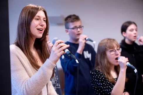 Vier Sänger und Sängerinnen während der Proben